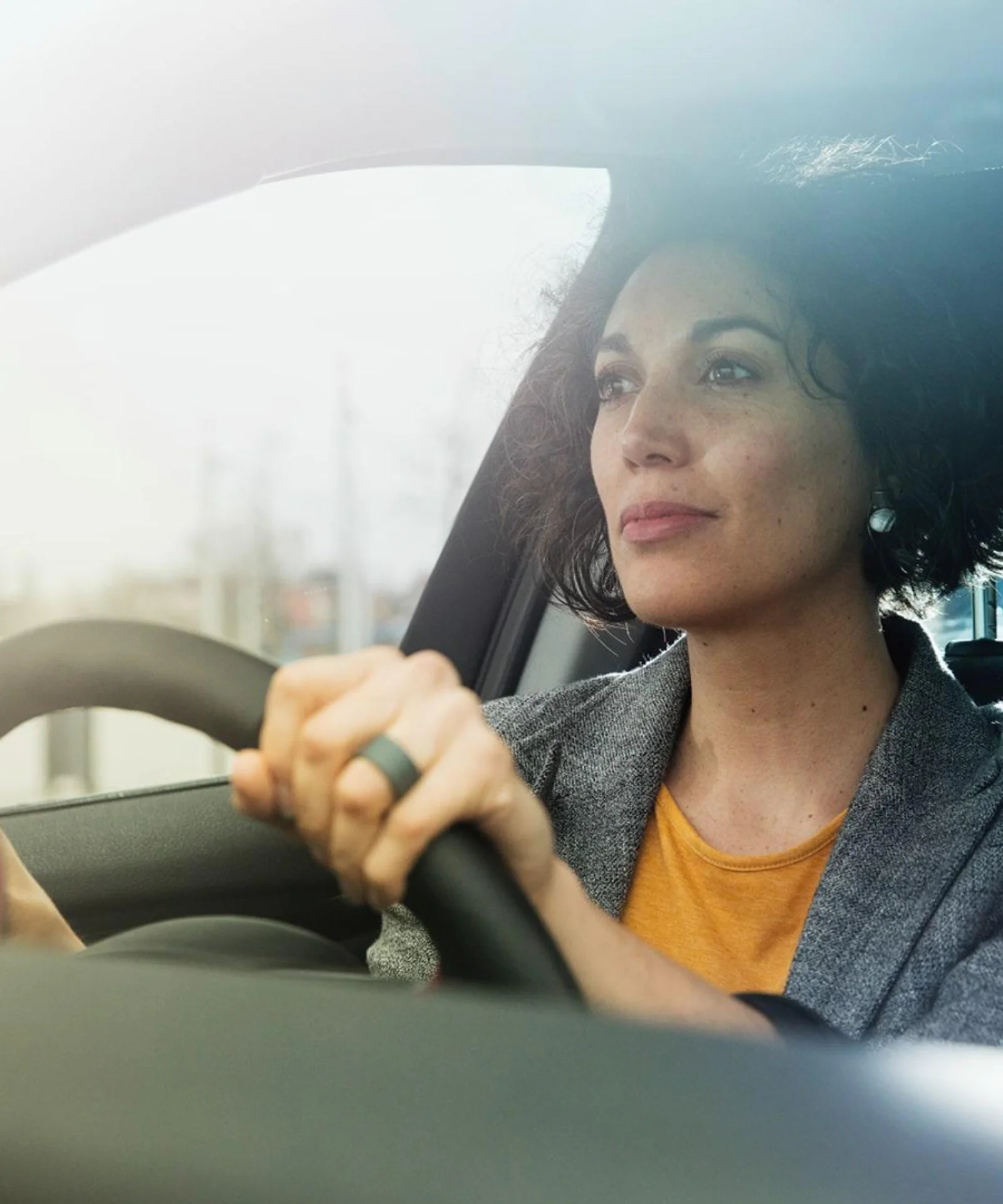 A focused woman driving a car, symbolising the journey of modernisation and innovation in the insurance sector.