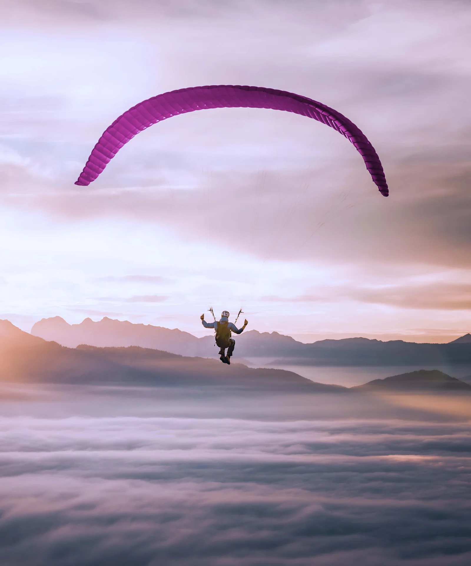 Ein Paraglider schwebt über den Wolken bei Sonnenaufgang, symbolisiert die Flexibilität und Freiheit in der Cloud-Nutzung, während gleichzeitig die Kontrolle über Kosten erhalten bleibt.