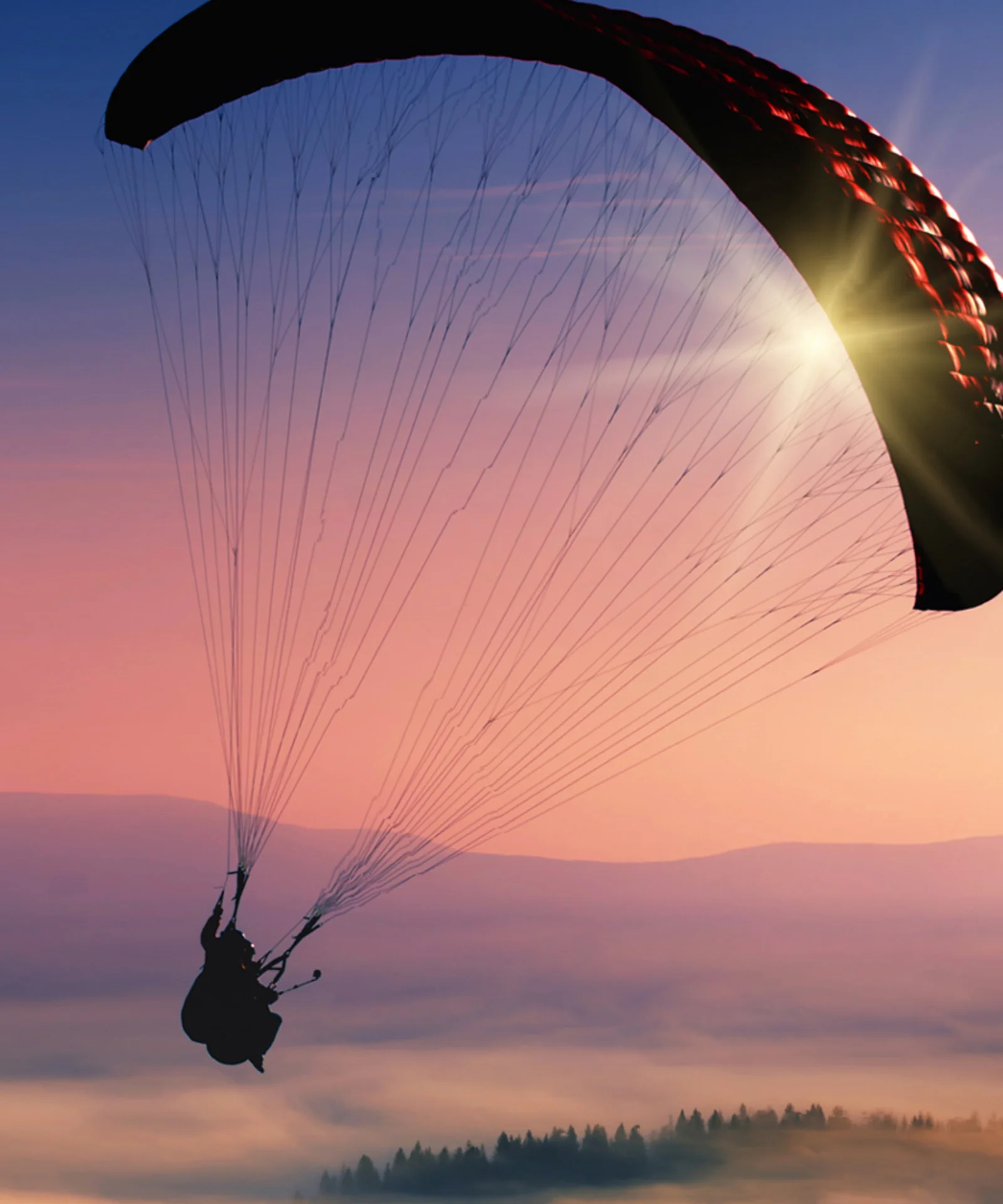 Una silueta impresionante de un parapente volando en un cielo de atardecer vibrante, que simboliza la libertad, la agilidad y las amplias posibilidades que ofrecen las soluciones híbridas y multicloud.