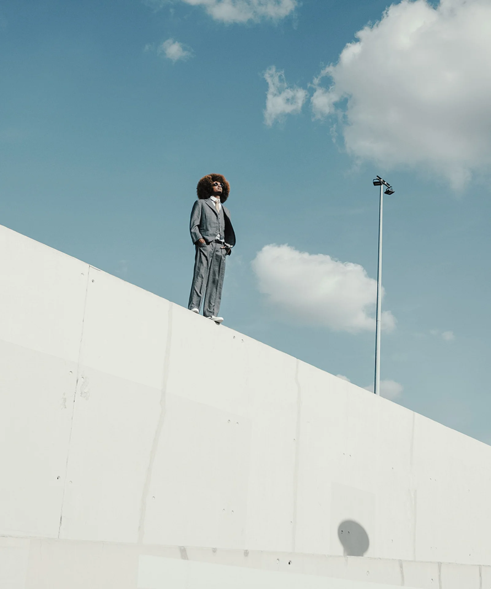 Confident professional standing on a modern architectural structure under blue sky gft-image-mood-08.jpg