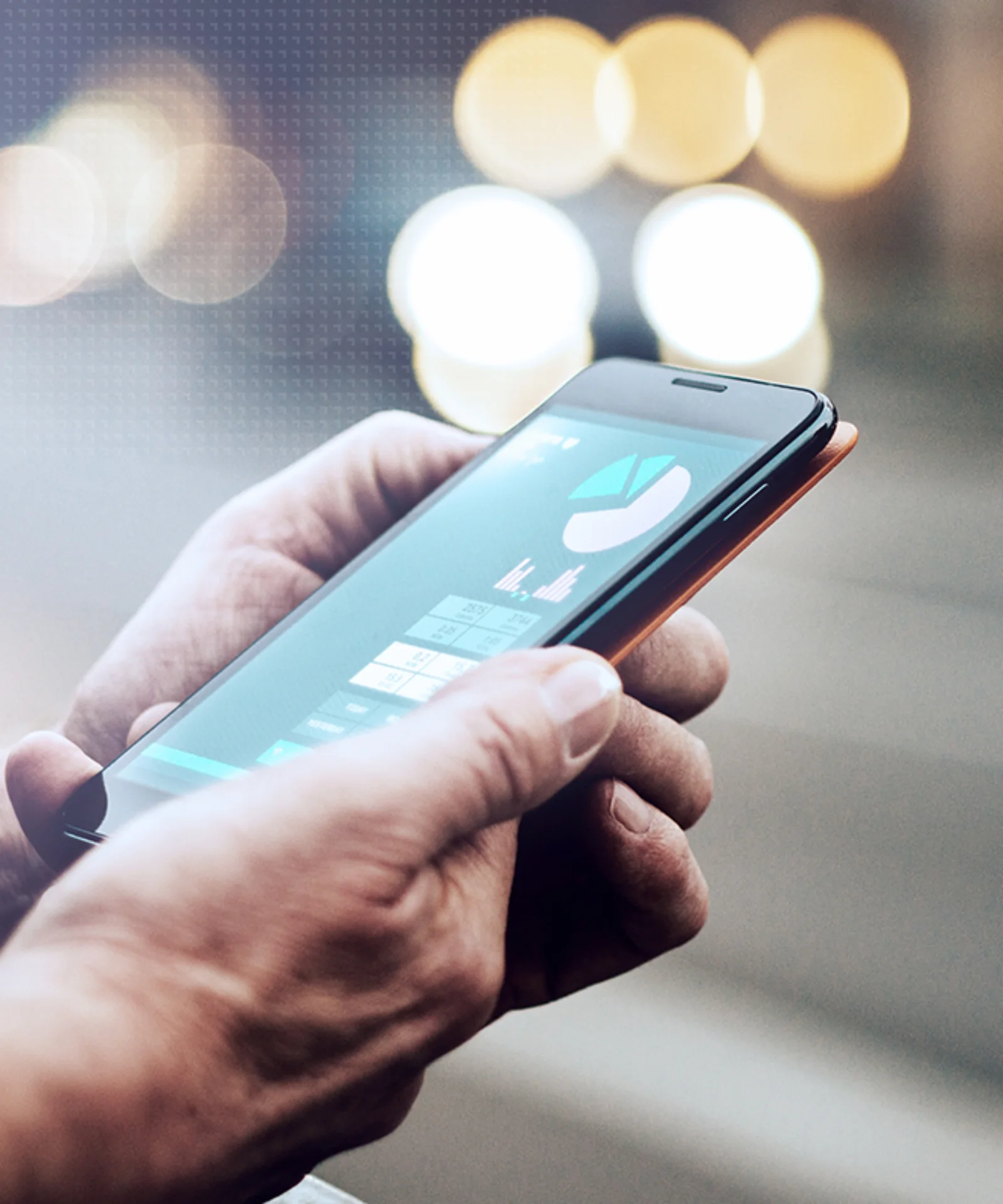 A person holding a smartphone displaying data visualizations, with blurred city lights in the background, representing mobile technology and data management.