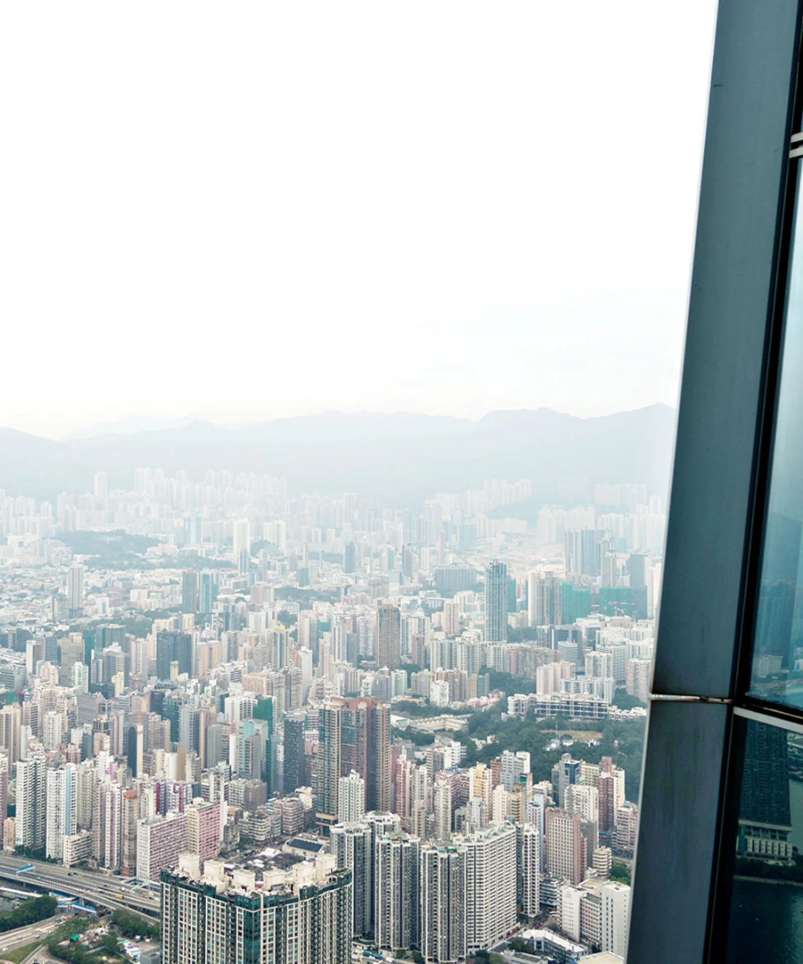 A panoramic view of a city skyline, with a reflection of a woman in a skyscraper window, symbolizing the contemplation of the future of banks in a rapidly evolving digital landscape.