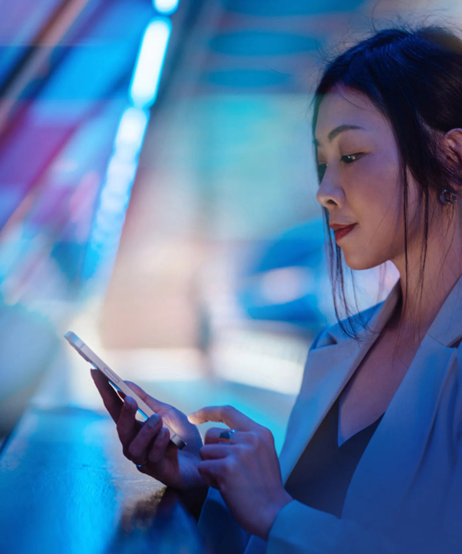 A professional woman using a smartphone, symbolizing the streamlined digital banking solutions offered by GFT.