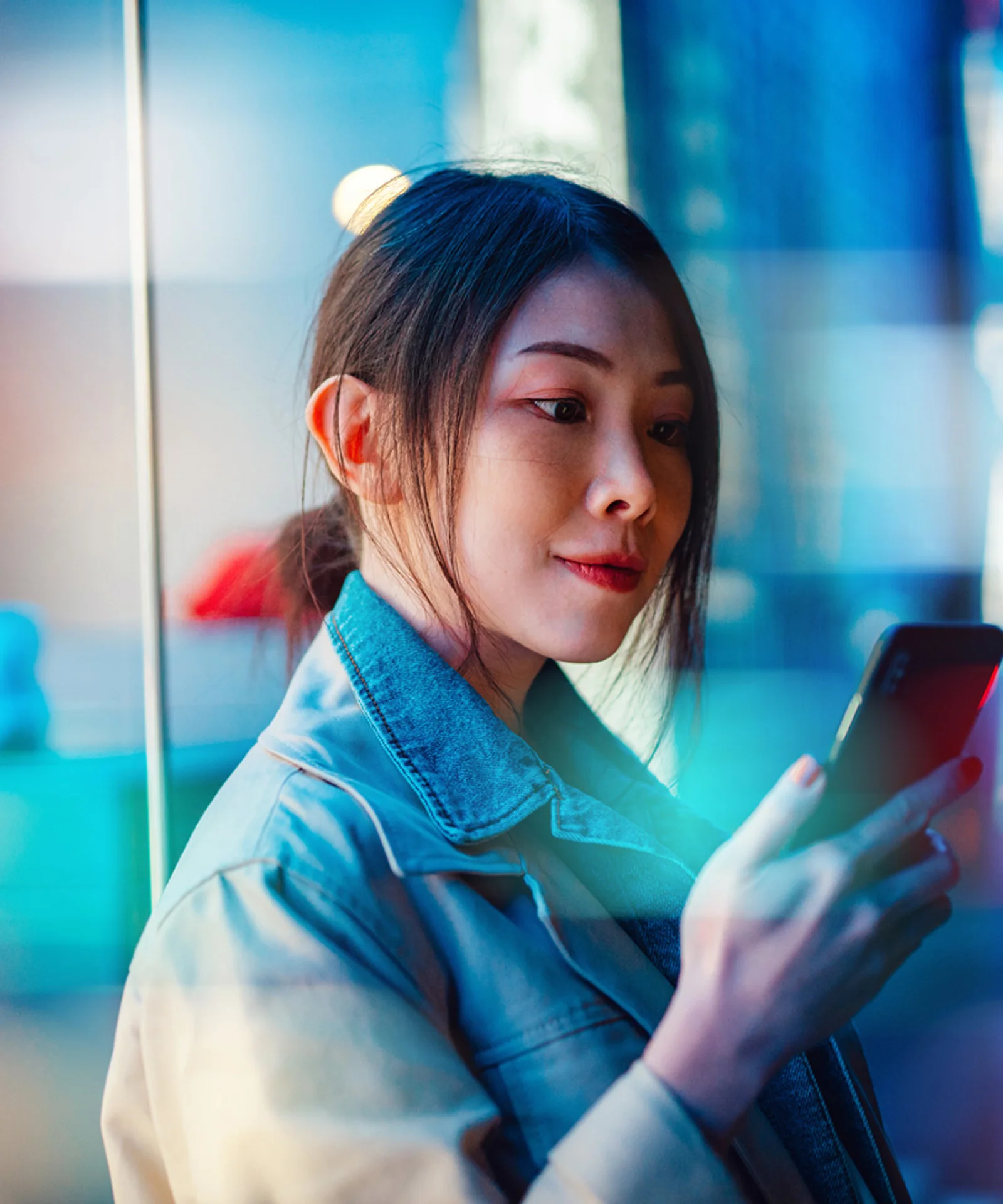 A woman using her smartphone, symbolizing the seamless integration and interoperability of digital payment systems in the regulated financial ecosystem.