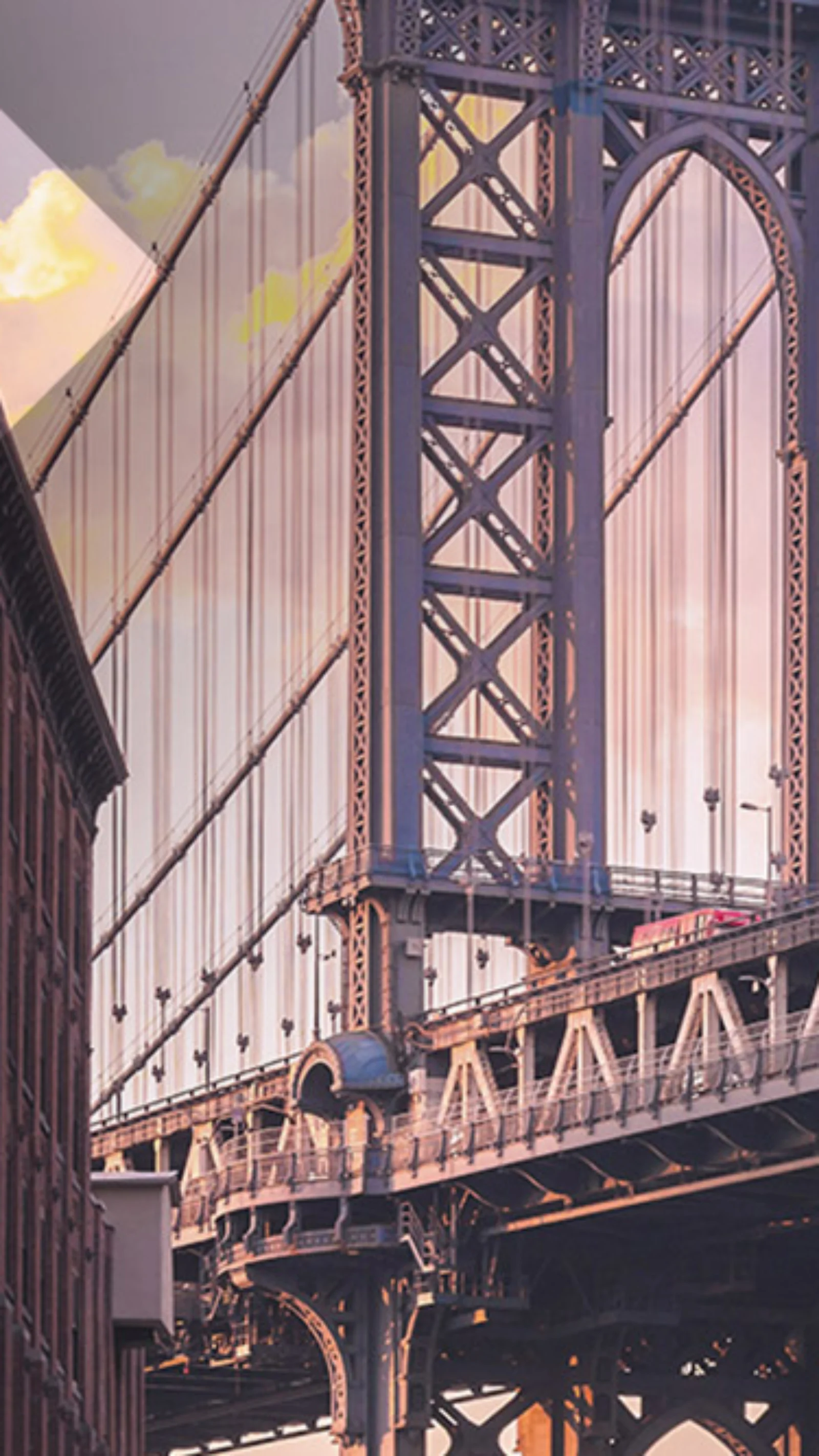 A view of the Manhattan Bridge framed by tall urban buildings at sunset, showcasing the architectural beauty and urban landscape of New York City.