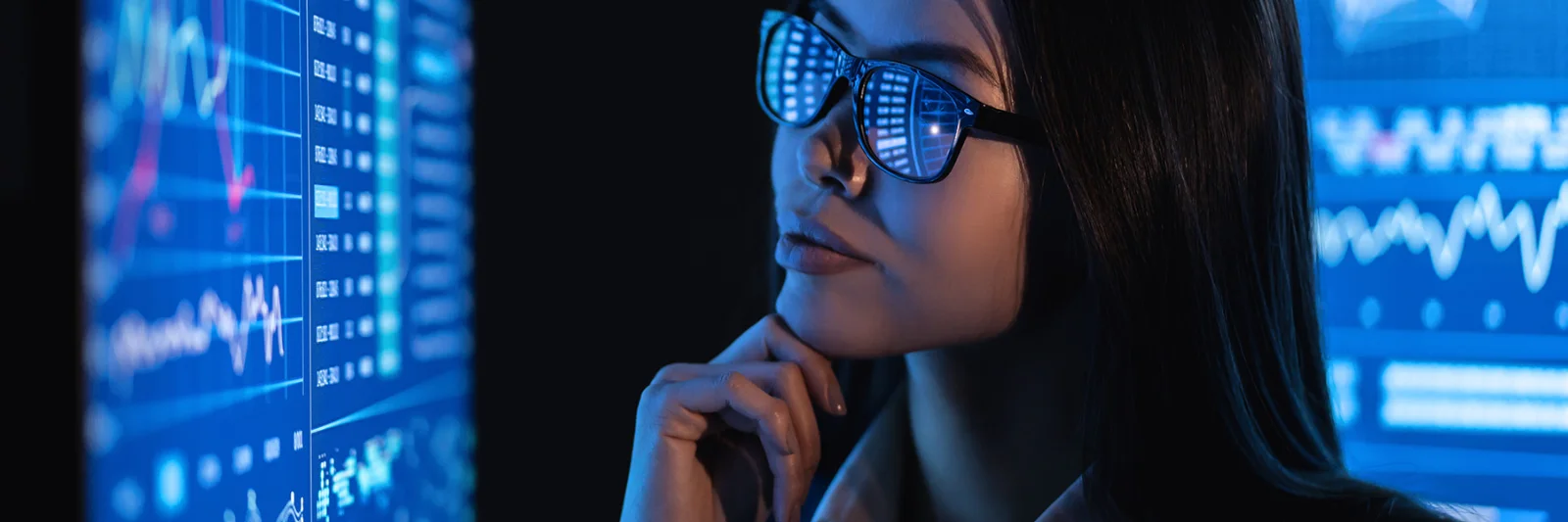 This key visual for Anthos depicts a focused woman wearing glasses that reflect data charts. She is gazing thoughtfully at several digital screens filled with diverse analytics, graphs, and data visualizations. The image conveys a sense of deep analysis, advanced technology, and data-driven decision-making, embodying the sophisticated capabilities and insights provided by Anthos. The blue-toned lighting and high-tech environment emphasize the modern and innovative nature of the Anthos platform.