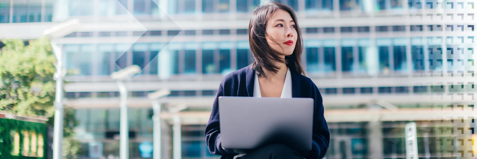 Headerbild einer Geschäftsfrau mit Laptop vor einem modernen Bürogebäude. Symbolisiert die T+1-Roadmap und die digitale Transformation der Finanzmärkte in Europa.