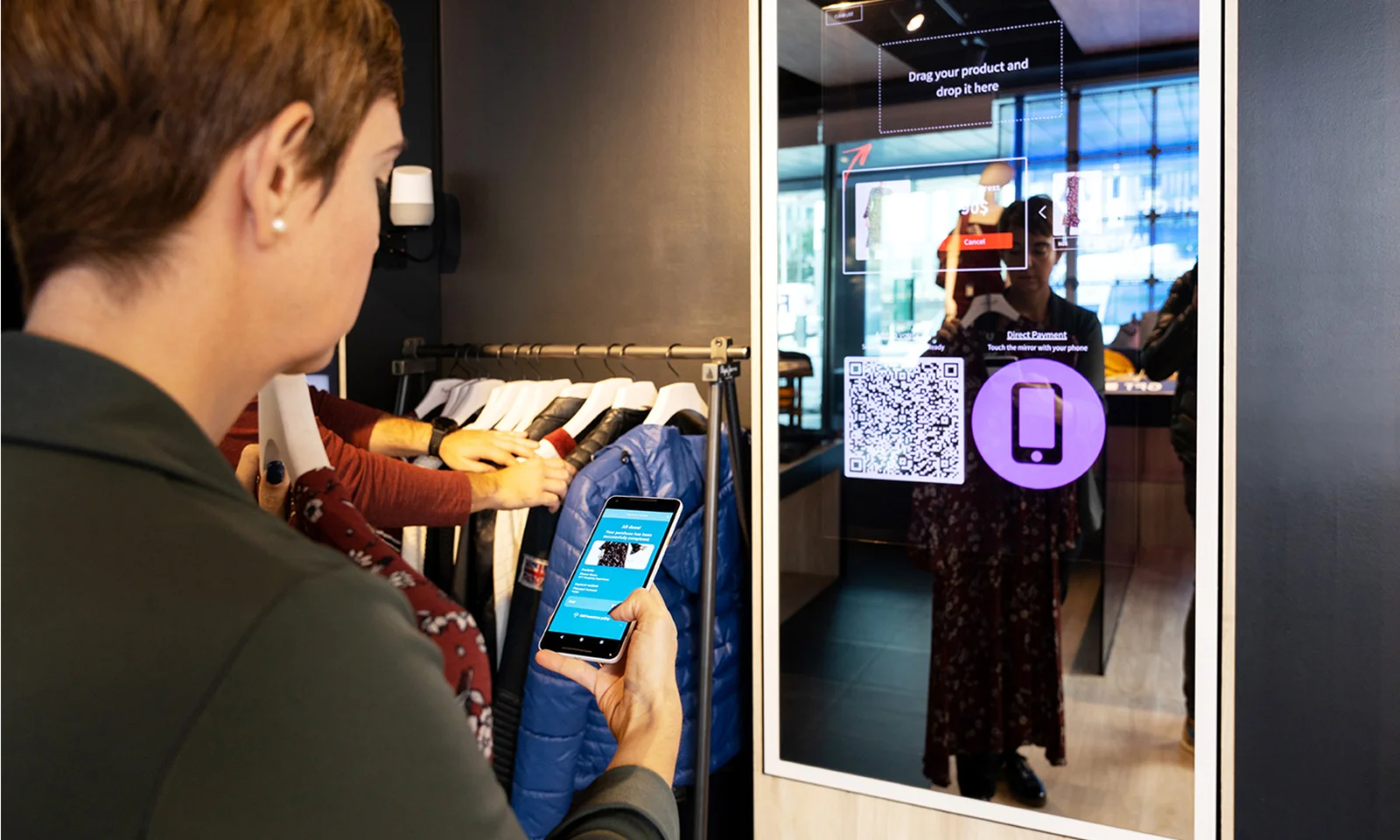 Discover the future of retail with our Design Product Innovation Workshop, featuring an interactive shopping experience. This image showcases a participant using a smartphone to interact with a smart mirror display, which provides product details, QR codes, and seamless payment options. Enhance customer engagement and streamline the shopping process with innovative retail solutions designed in our expert-led workshops. Transform your retail strategy with cutting-edge technology and interactive experiences.