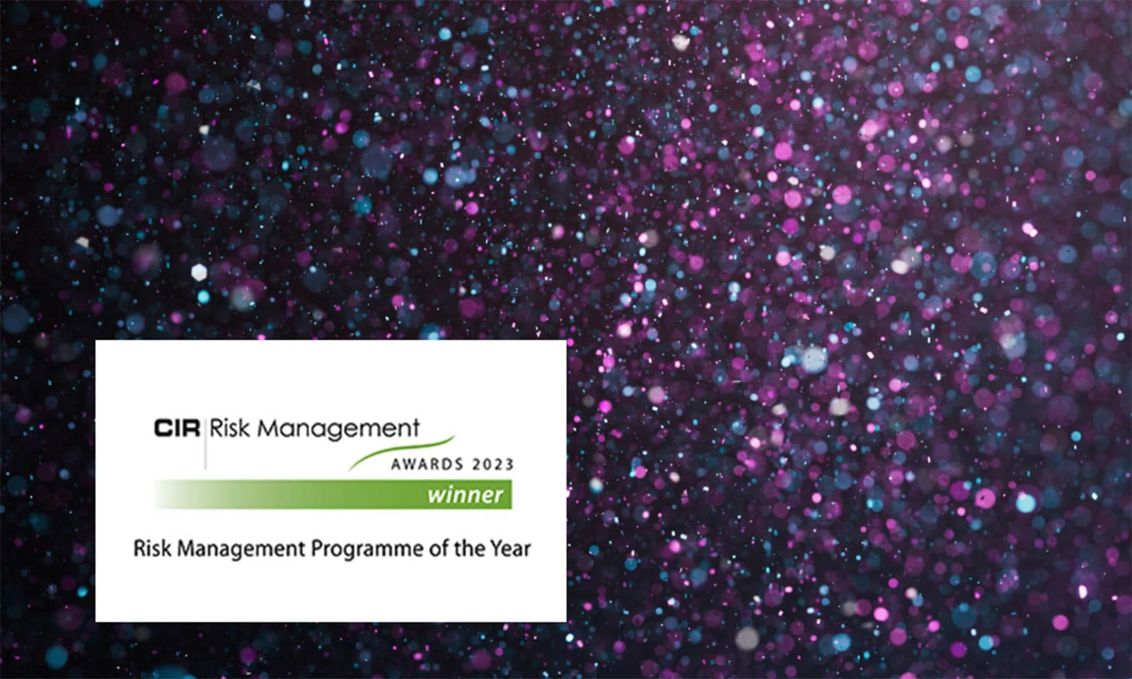 GFT recognised as the winner of the Risk Management Programme of the Year at the CIR Risk Management Awards 2023, displayed against a vibrant background with shimmering lights.