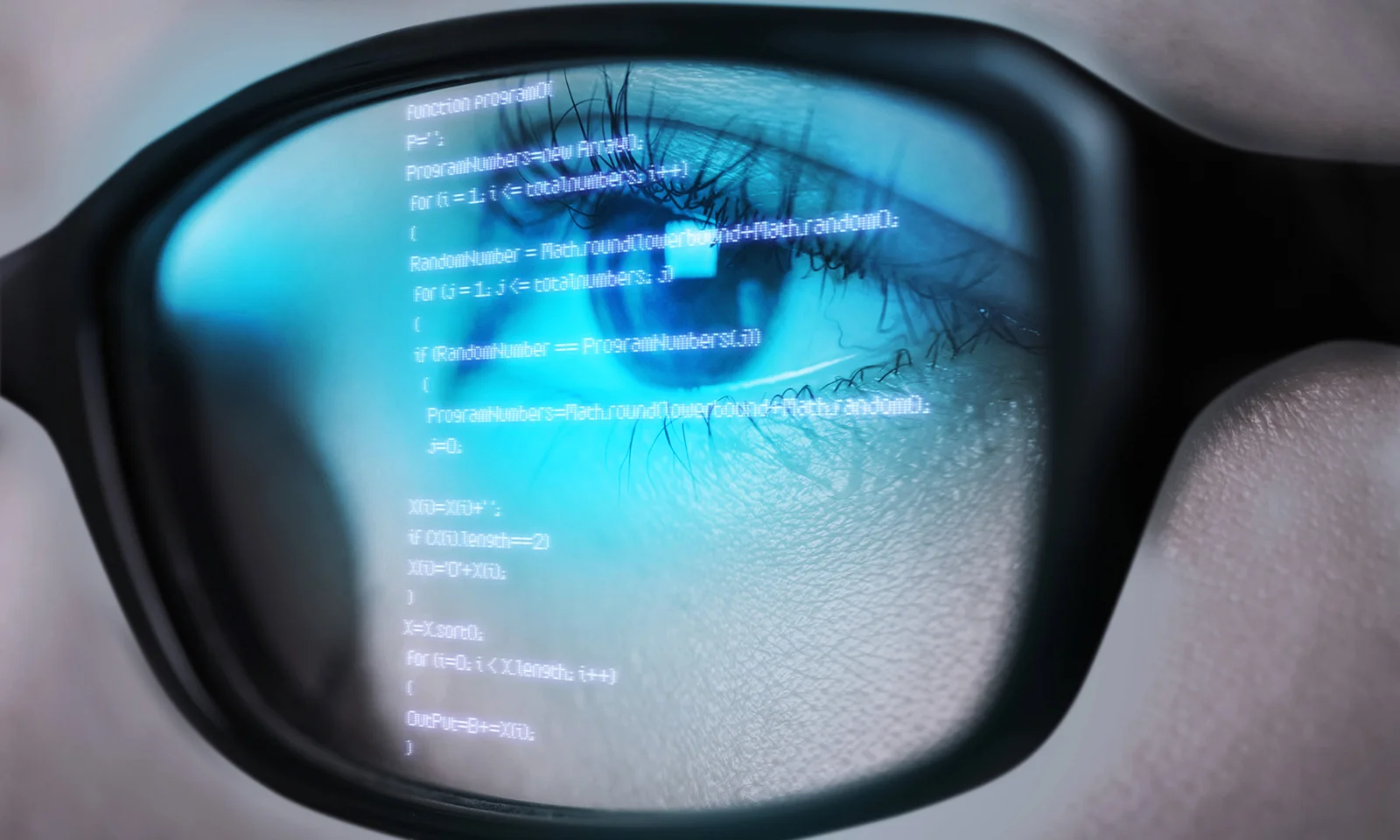 Close-up of a person&#039;s eye reflecting code on a screen, symbolizing in-depth analysis and focus in software development.