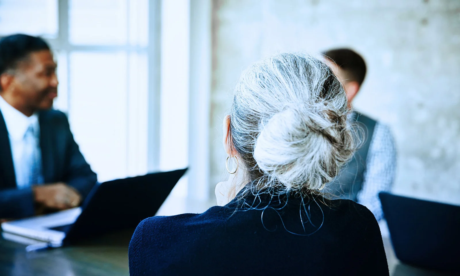 Imagen clave para relaciones con inversores que presenta una reunión de negocios centrada en una mujer de alto nivel, destacando la diversidad y el profesionalismo en las relaciones con inversores.