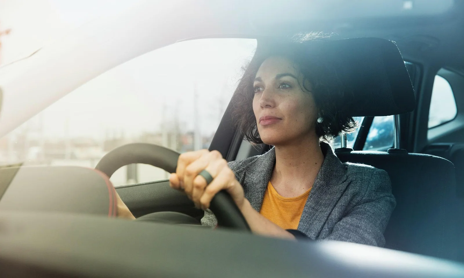 A focused woman driving a car, symbolising the journey of modernisation and innovation in the insurance sector.