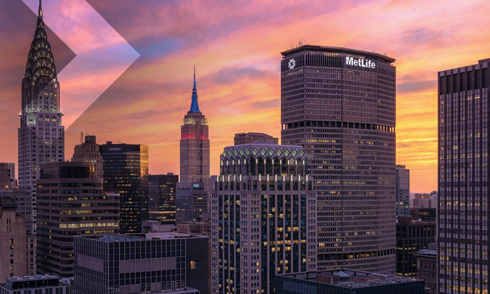 Stunning New York City skyline at sunset, showcasing iconic architecture like the Chrysler Building and MetLife Building against a colorful sky. Ideal representation of urban innovation and architectural beauty.