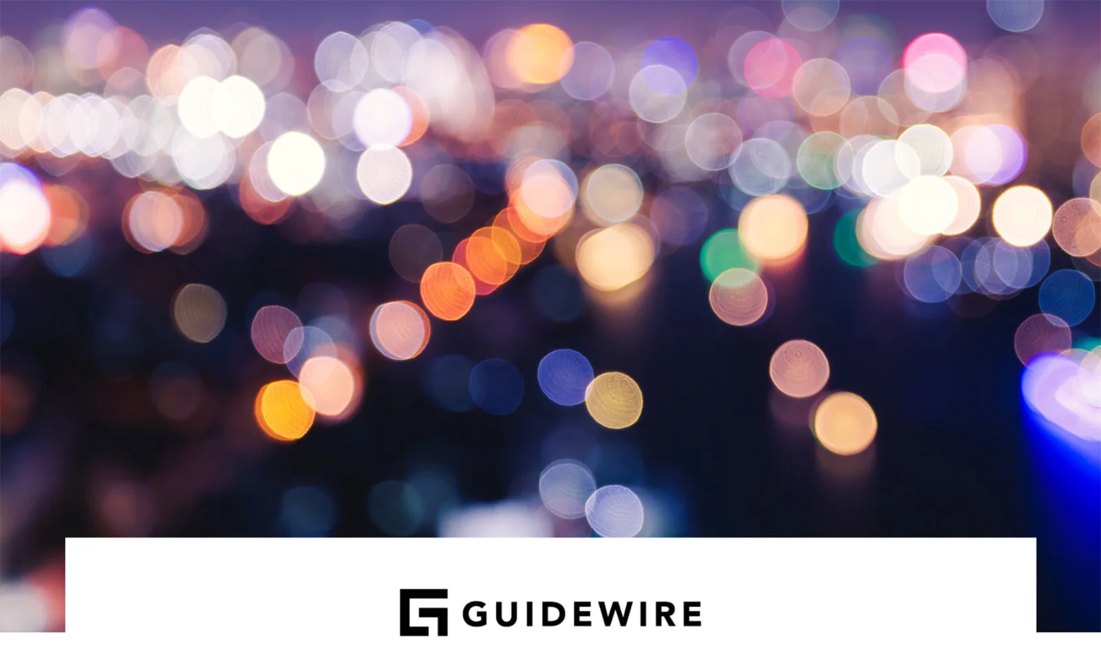 A colorful, abstract cityscape with out-of-focus lights, symbolizing the vibrant and dynamic nature of platform modernization. The Guidewire logo is prominently displayed at the bottom.