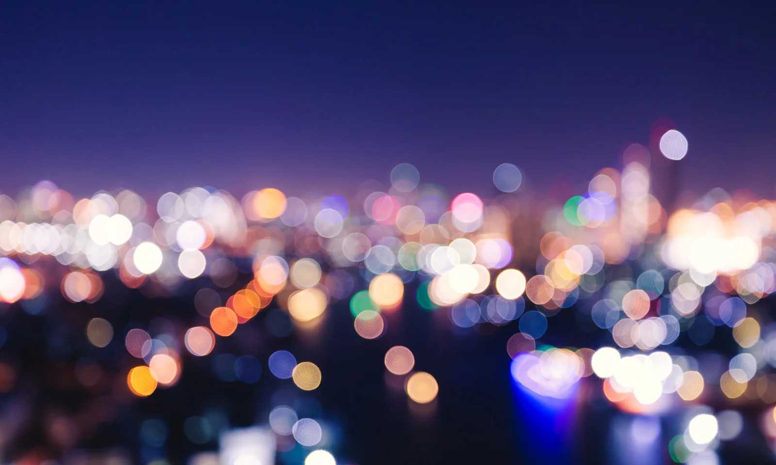 Abstract blurred city lights at night, representing opportunities and challenges.