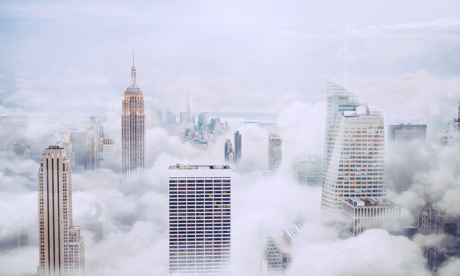 A breathtaking view of skyscrapers towering above the clouds in a misty cityscape, symbolising innovation and modern architecture.