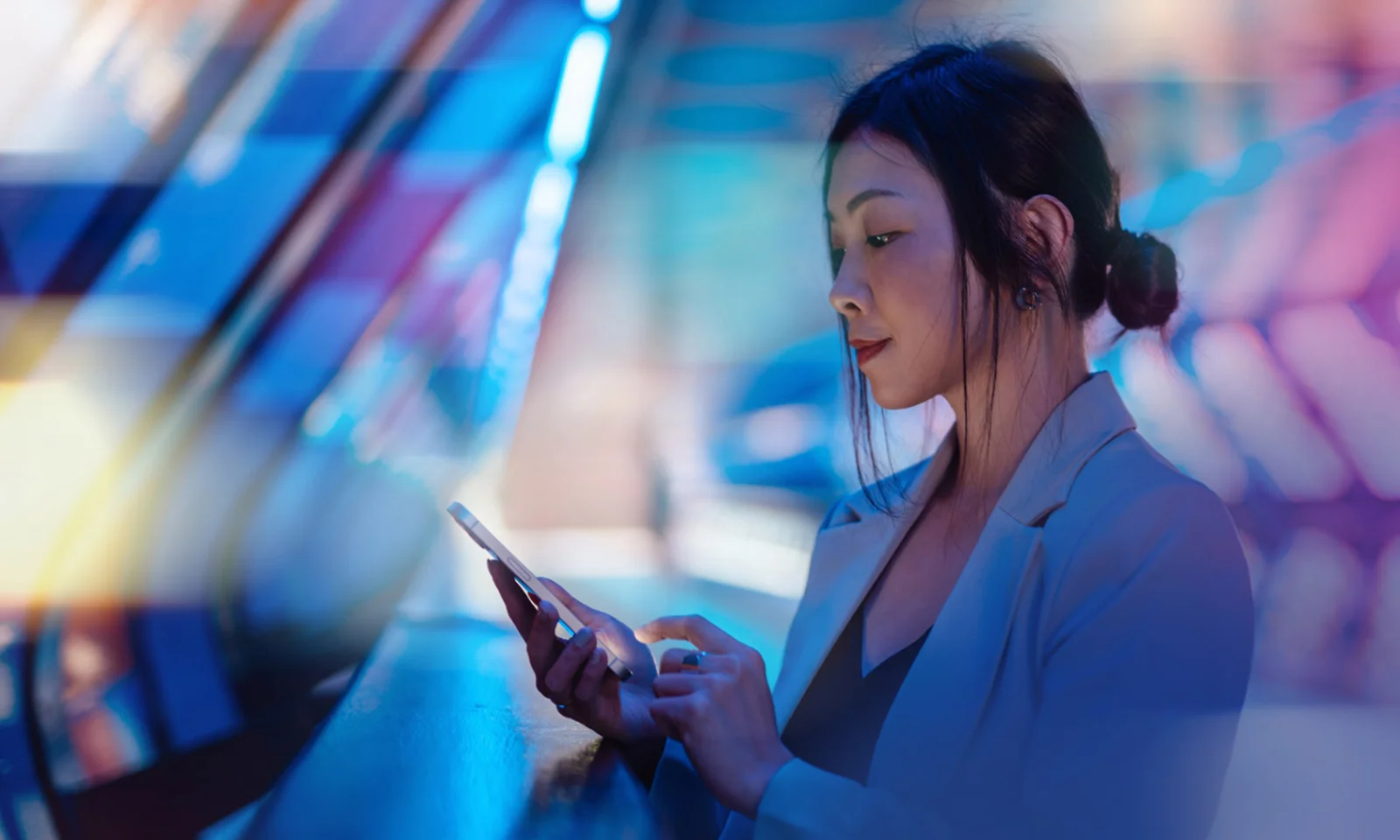 A professional woman using a smartphone, symbolizing the streamlined digital banking solutions offered by GFT.