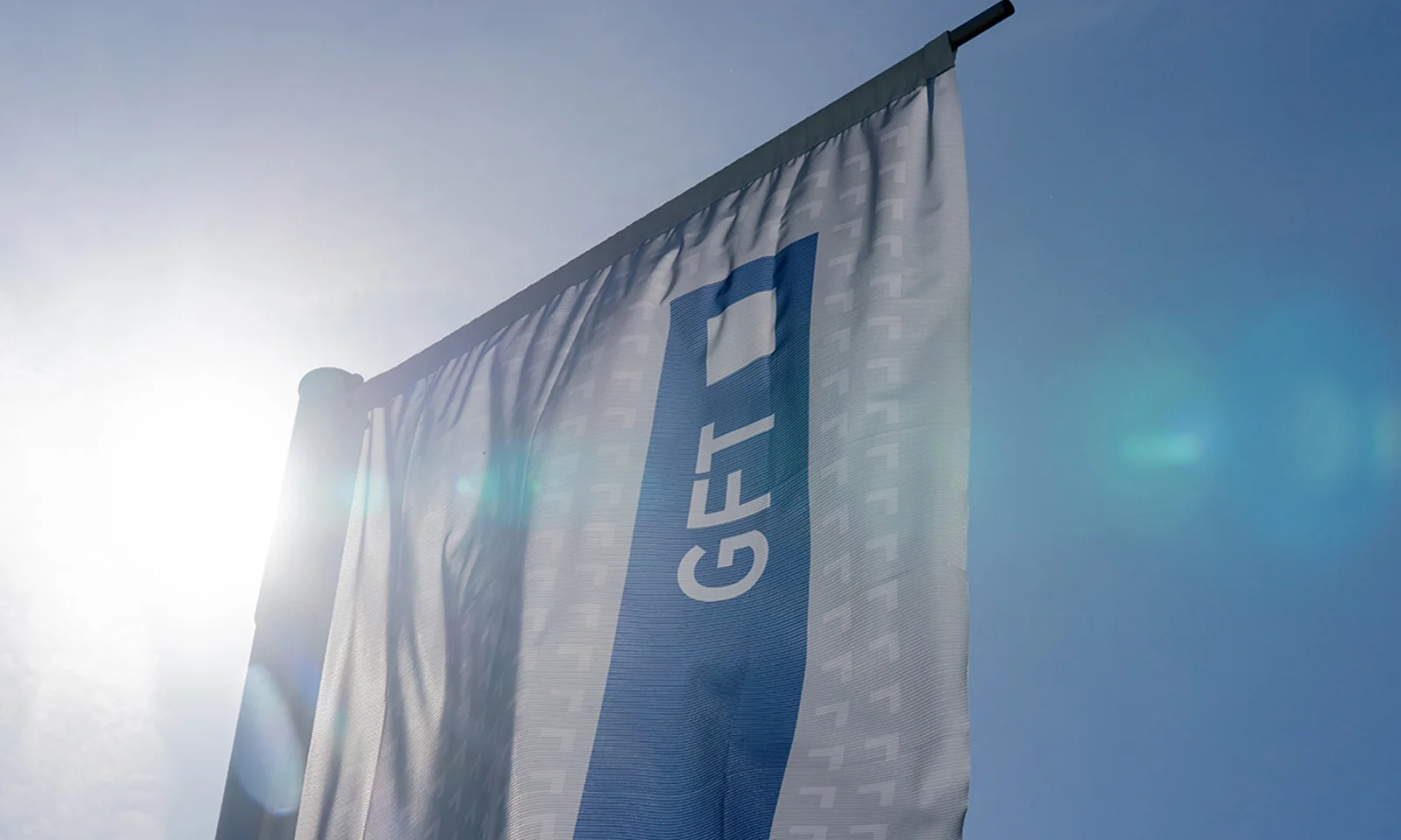 A GFT flag waving in the bright sunlight, symbolising the company&#039;s presence and commitment to excellence.